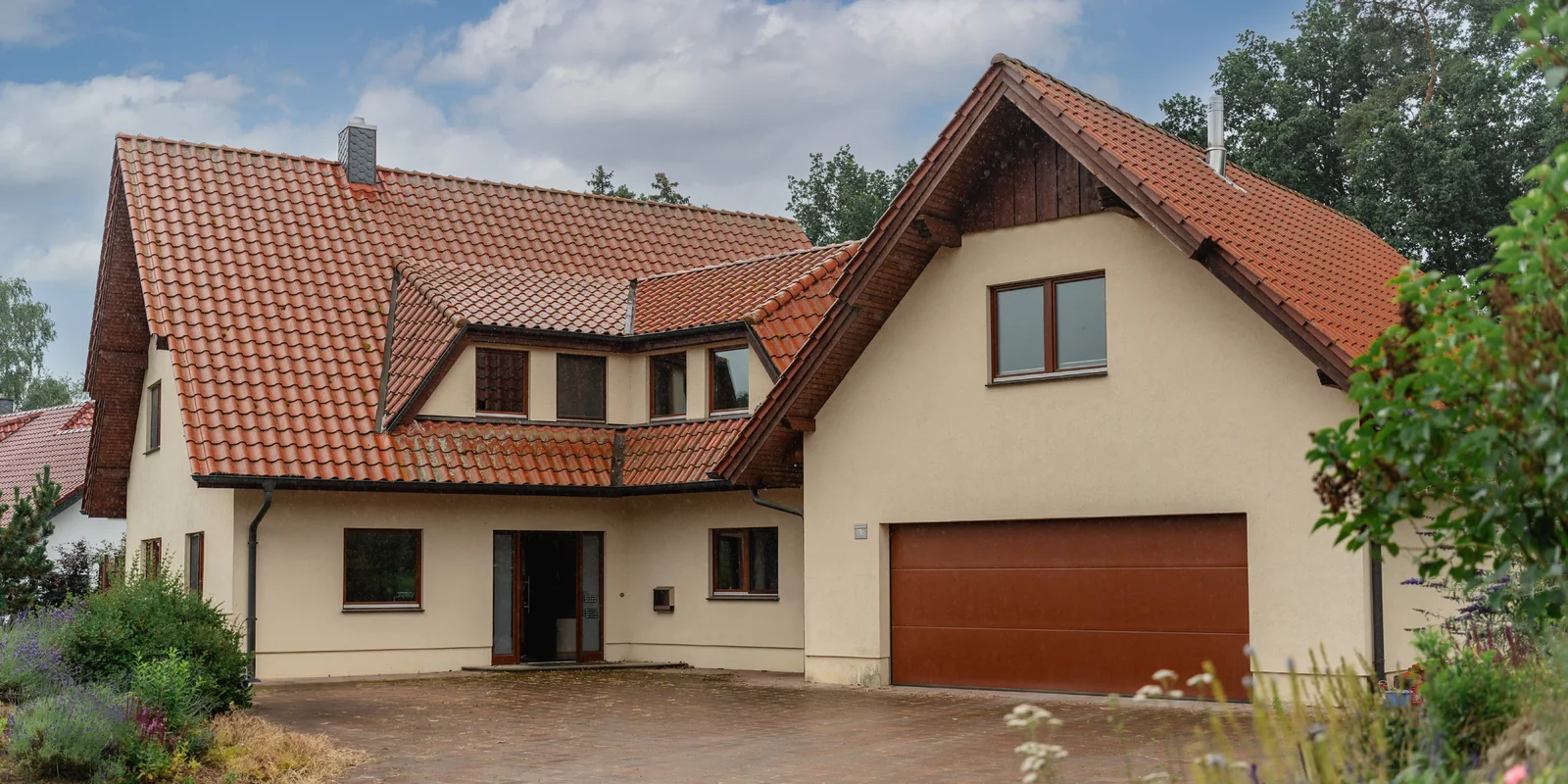 Außenansicht des bereits vermittelten Wohnhauses in Ostercappeln–Venne mit Ziegeldach und Garage