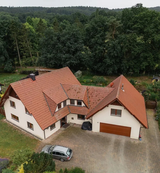 Luftaufnahme des Wohnhauses in Ostercappeln-Venne mit Zufahrt, Garten und angrenzenden Bäumen
